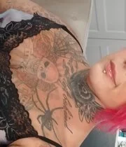 Pink haired chick puts her tattooed body on display